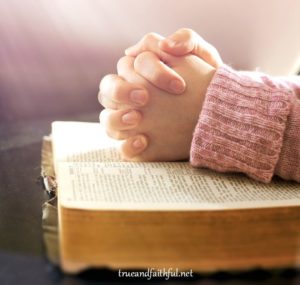 Woman's Hands In Prayer Over An Open Bible
